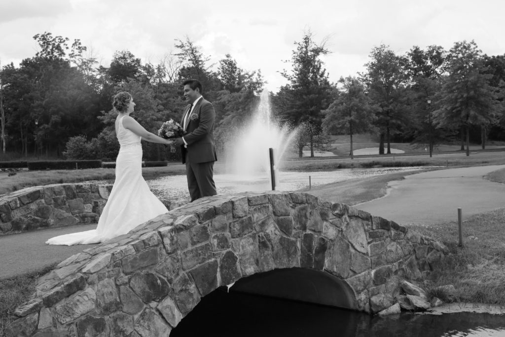 Latin couple holding hands on bridge