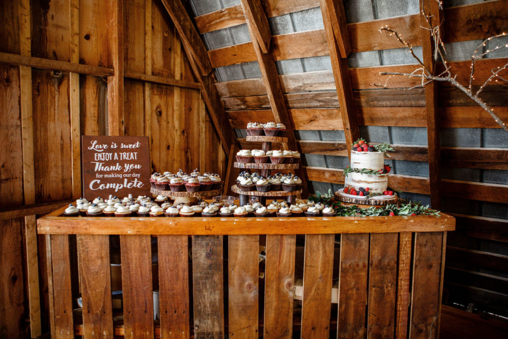 wedding dessert bar with cake and cupcakes at east lynn farm hayloft