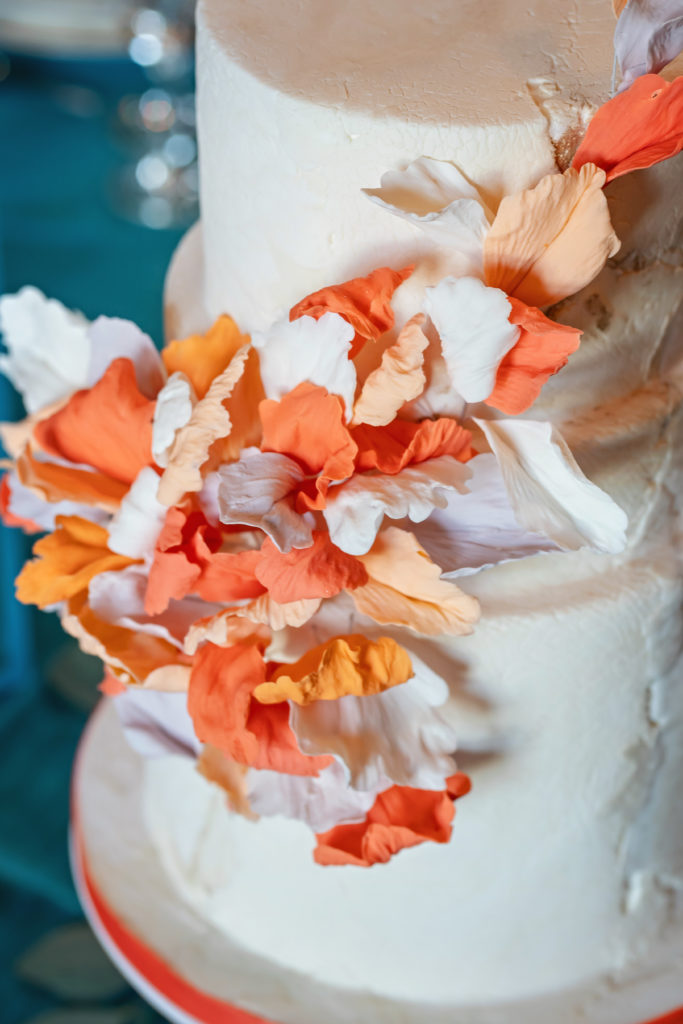 Orange and white sugar flowers in wedding cake