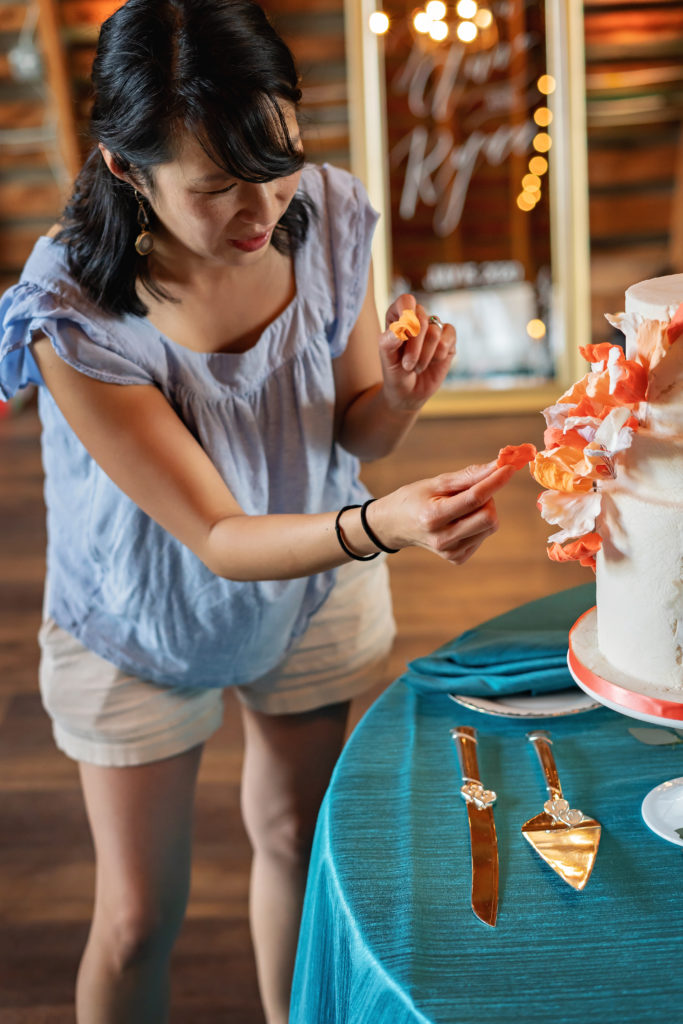 warrenton baker decorating a wedding cake with sugar flowers