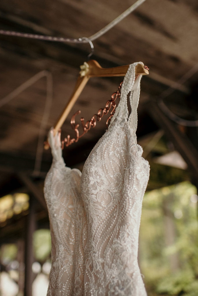 sheer appliqued bodice with sleeveless V-neckline wedding gown on hanger