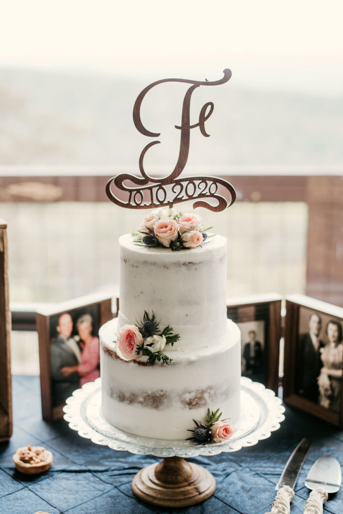 two tier wedding cake with rustic finish decorated with garden roses and ranunculus