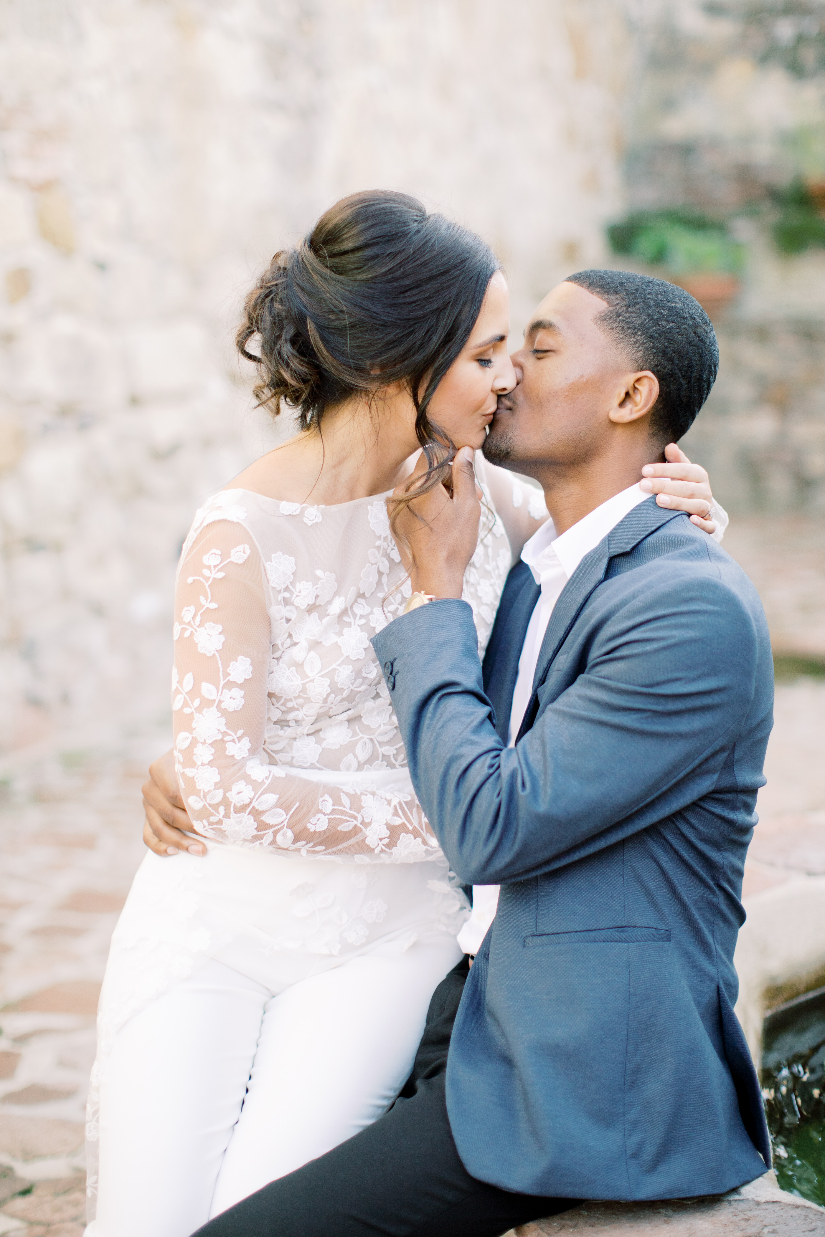 Bride with a white jumper kissing her groom with blue suit during their elopement wedding