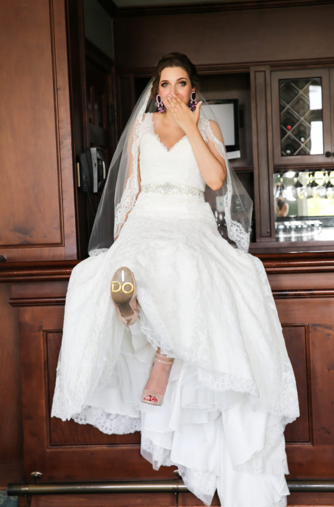 bride sitting in the bar with I do stickers on her shoe