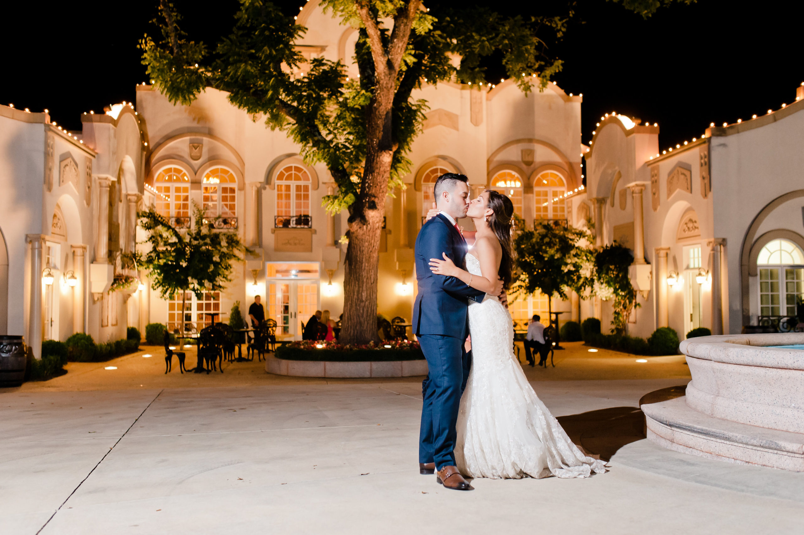 couple kissing in front of Morais Vineyard ballroom