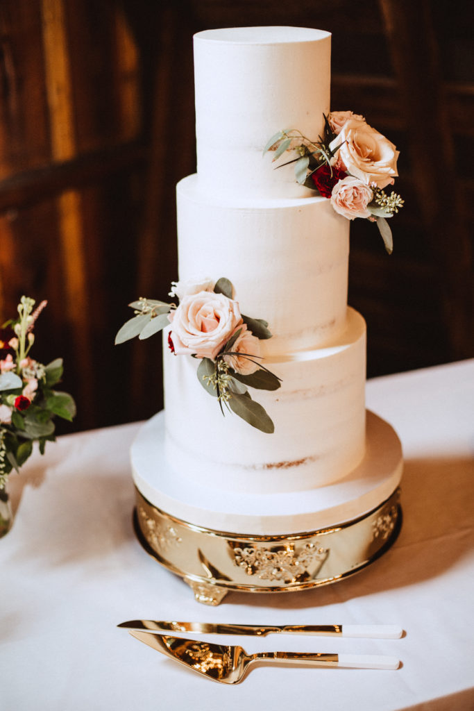 White three tier wedding cake with blush roses