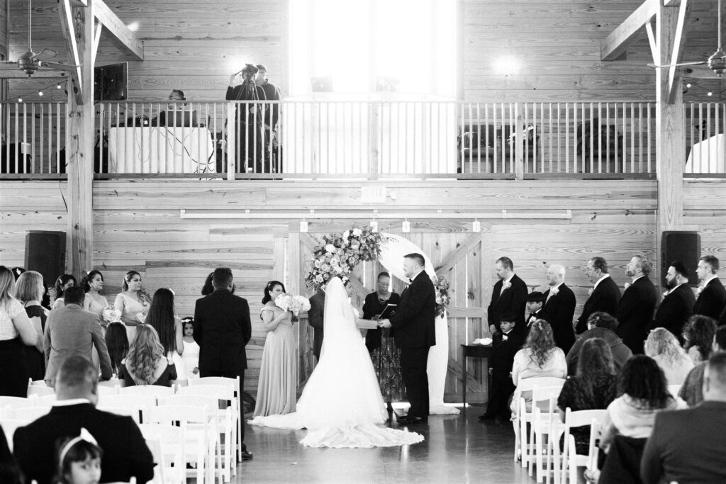 Bride and Groom in indoor ceremony at Middleburg barn with iron arch